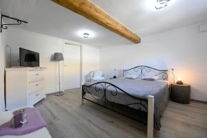 een slaapkamer met een bed, een ladekast en een televisie bij Villa Beatrice by Locap Group in Izola