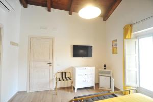 ein Schlafzimmer mit einem Bett, einer Kommode und einem TV in der Unterkunft La Casa di Nenna in Trentinara