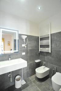 een badkamer met een wastafel, een toilet en een spiegel bij La Casa di Nenna in Trentinara
