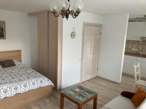 a bedroom with a bed and a couch and a table at Baltic Sea Beach Apartment in Liepāja