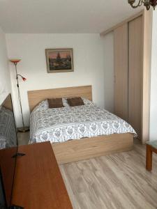 a small bedroom with a bed and a table at Baltic Sea Beach Apartment in Liepāja