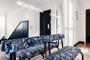 a living room with a blue and white couch at Hôtel Le Windsor Biarritz in Biarritz