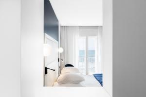 a bedroom with a mirror and a bed and a window at Hôtel Le Windsor Biarritz in Biarritz