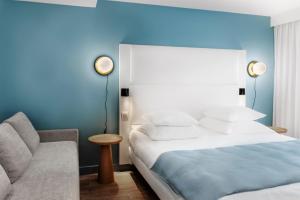 a bedroom with a bed and a couch at Hôtel Le Windsor Biarritz in Biarritz