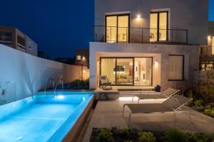 a villa with a swimming pool at night at Nisi Living Concept in Ialyssos