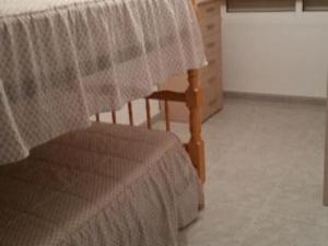 um quarto com uma cama, uma mesa e uma cadeira em Apartamento Finisterra em Fisterra