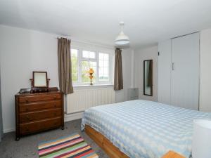 a bedroom with a bed and a dresser and a window at 1 Eastview in Louth