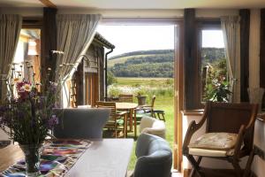 a room with a table and chairs and a large window at A Barn at South Downs Stay in Houghton