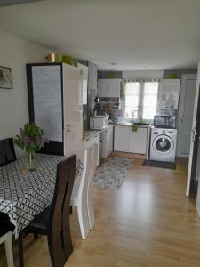 a kitchen with a table and a kitchen with a washing machine at Gite Ray . in Brévonnes