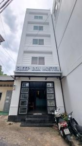 a large building with a motorcycle parked outside of it at Sleep Box Hostel Phú Quốc in Phú Quốc