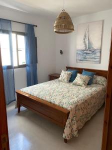 a bedroom with a bed with a sailboat on it at Eterna Primavera, a 40m de la piscina natural in Punta Mujeres