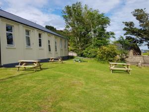 dos mesas de picnic en un patio al lado de un edificio en Helmsdale Lodge Hostel - all rooms en-suite en Helmsdale