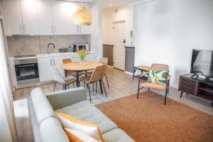 a living room with a couch and a table and a kitchen at Casa dos Capuchos in Leiria
