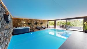 a swimming pool in a house with a stone wall at Ferienhof A&B Wellness Villa 6 personen in Bullange