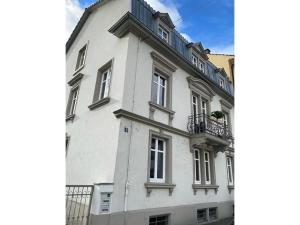 a white building with a balcony on top of it at annadaly Stadtraumwohnung in Lörrach