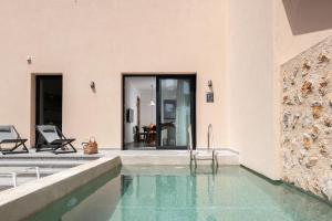 a house with a swimming pool and a patio at Nisi Living Concept in Ialyssos