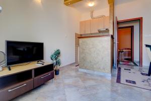 ein Wohnzimmer mit einem TV und einer großen Schiebetür in der Unterkunft La Castagna Apartments in Kotor