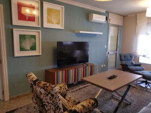 a living room with a television and a table and chairs at MRZ RENTALS JEREZ in Jerez de la Frontera