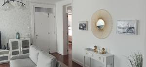 a living room with a chair and a mirror at Alojamento Pestana in Horta