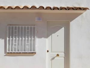 una puerta blanca con una ventana en una pared blanca en Torbellino de Colores, en Benaguacil