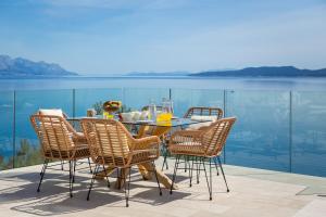 mesa de comedor y sillas con vistas al agua en Beachfront Holiday Home - Private Heated Pool, en Mimice