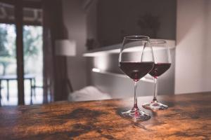 dos copas de vino tinto en una mesa de madera en Villaggio Ca' Laguna, en Grado