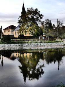 a reflection of a church in a body of water at Ferienwohnung Schlesinger in Hohnstein