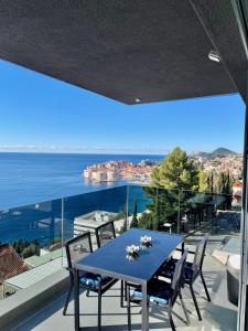 a blue table on a balcony with a view of the ocean at Apartments Fortes Fortuna in Dubrovnik