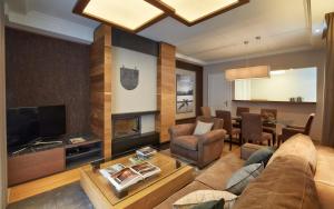 a living room with a couch and a television at Grand Hotel des Bains Kempinski in St. Moritz