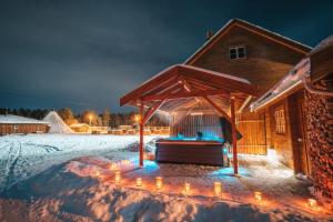 une maison avec un kiosque dans la neige dans l'établissement Holmen Husky Lodge, à Alta