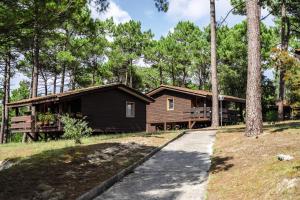 a log cabin in the woods with a driveway at Belambra Clubs Résidence Carcans - Les Sentes in Carcans