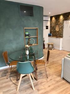 une salle à manger avec une table et des chaises en verre dans l'établissement La Fabrique Centre ville - Berges du Tarn, à Millau