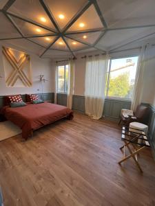 - une chambre avec un grand lit et une grande fenêtre dans l'établissement La Fabrique Centre ville - Berges du Tarn, à Millau
