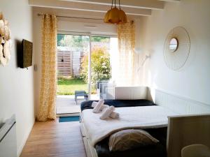 a bedroom with a bed and a large window at "Studiocaroline44", entre la ville et la mer, Parking, Wifi, terrasse privé, cuisine, moins de 15min aéroport in Bouaye
