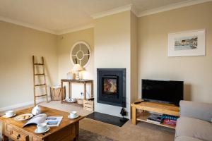 a living room with a tv and a fireplace at Highlands in Port Isaac
