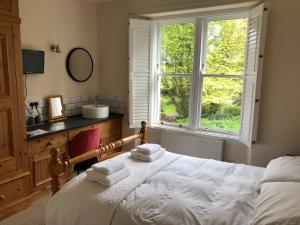 una camera con letto, lavandino e finestra di Giltar Grove Country House a Tenby