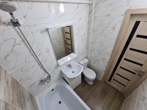 uma casa de banho branca com um lavatório e um WC em Квартира посуточно в центре г.Петропавловска em Petropavl