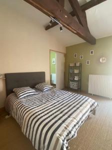 - une chambre avec un grand lit et des draps rayés dans l'établissement Maison de ville #toutfaireapied #proche gare, à Cognac