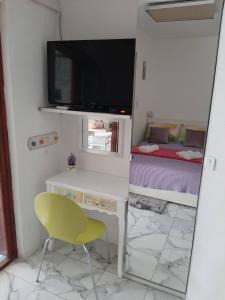 Habitación con escritorio, TV y silla. en STUDIO APARTMAN LAURA, GAJAC, PAG, en Novalja