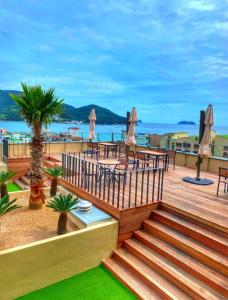 a wooden deck with tables and chairs on the beach at Geoje Mongdol Beach H Avenue Hotel in Geoje