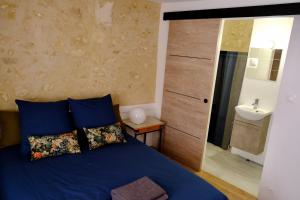 1 dormitorio con cama azul y lavamanos en Le Clou, en Chauvigny