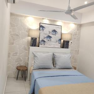 - une chambre avec un lit et une peinture murale dans l'établissement Waterside Apartments, à Agia Effimia