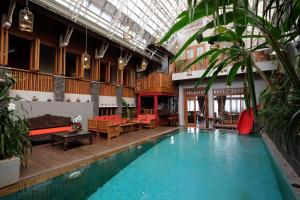 a large swimming pool in a large building with a room with at Rumah Stroberi Organic Farm & Family Lodge in Lembang