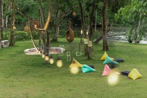 a group of colorful kites sitting on the grass at The Tree Riverside Kaeng Krachan in Kaeng Krachan