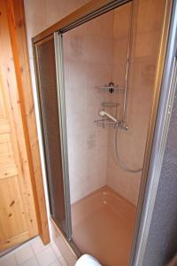 um chuveiro com uma porta de vidro na casa de banho em Herzmuschel em Hörnum
