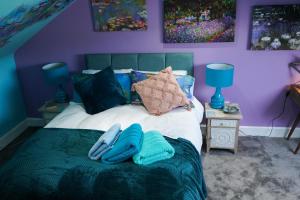 um quarto com uma cama com toalhas azuis em The Art Bank em Dalbeattie