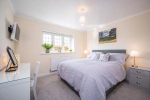a white bedroom with a bed and a desk at Luxury, Spacious Cottage in the Black Mountains in Hereford