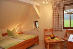 een slaapkamer met een bed, een tafel en een raam bij Ferienhof Schönfelder in Königstein an der Elbe