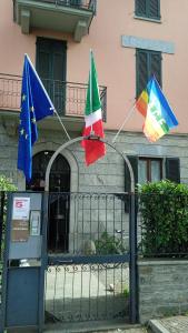 コモにあるジラ ゲストハウスの二旗が柵に取り付けられている