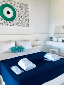 una camera da letto con un letto e asciugamani di Rigas Rooms a Città di Skiathos